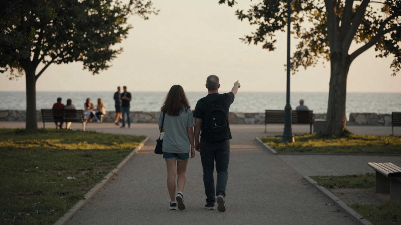 Two people walking calmly through a quiet Gebze park, overlooking the Sea of Marmara at sunset.