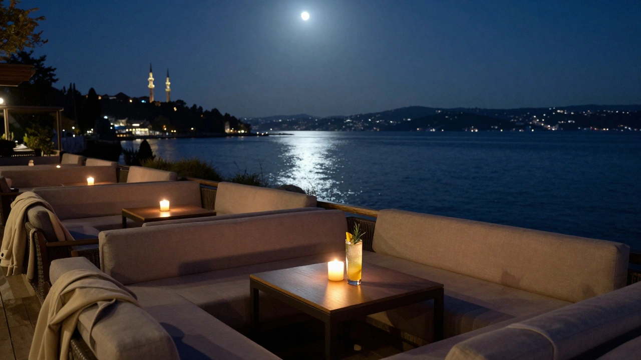 Kuleli Beach Club at night with candlelit tables and moonlit Bosphorus, a jacket draped over a chair.